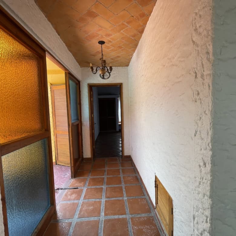Balcony corridor with terracotta tiles and rustic decor, perfect for enjoying outdoor views and rela.