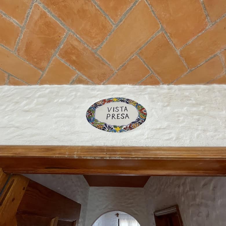 Scenic property entrance with "Vista Presa" sign above the door.