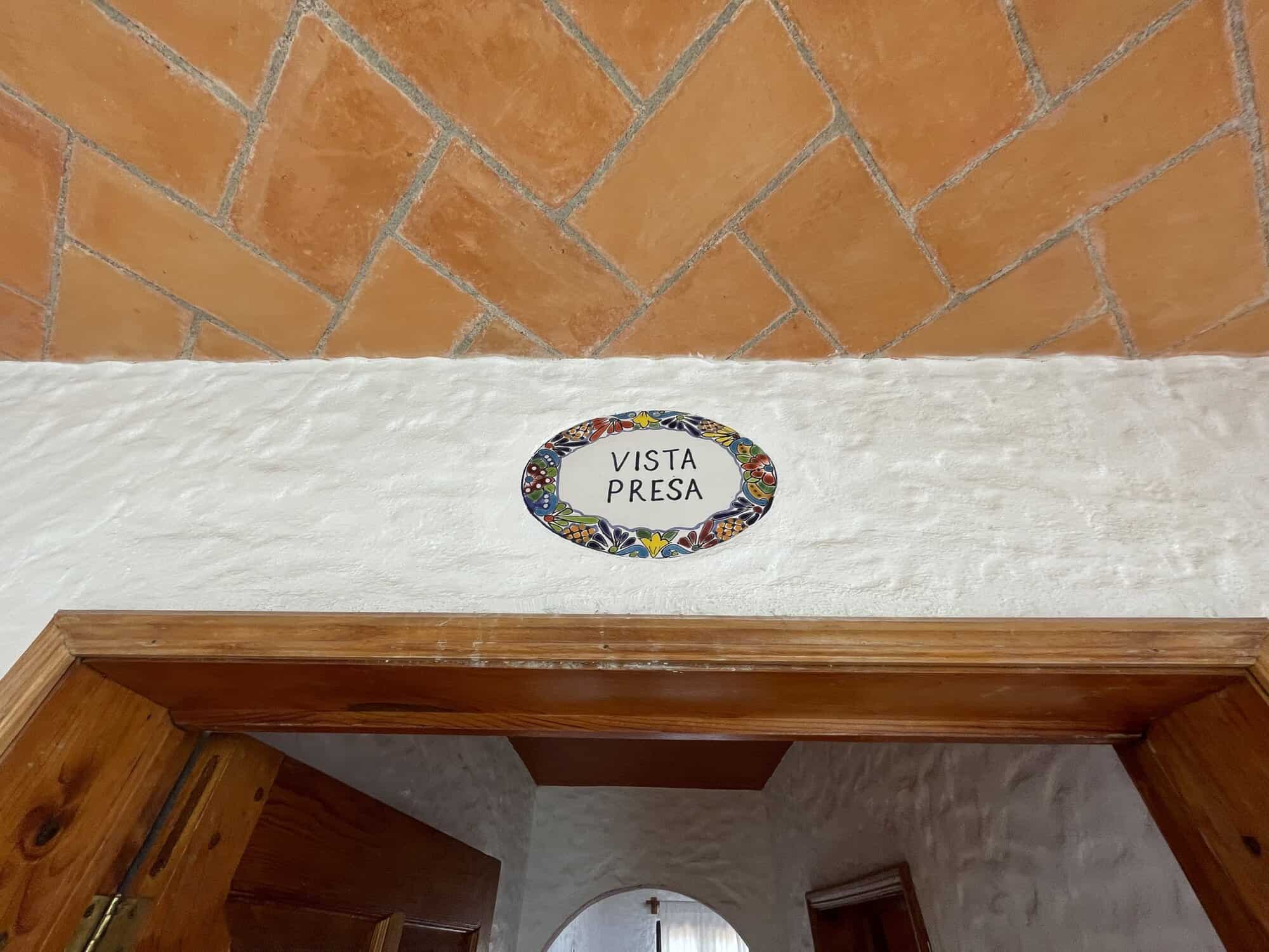 Scenic property entrance with "Vista Presa" sign above the door.