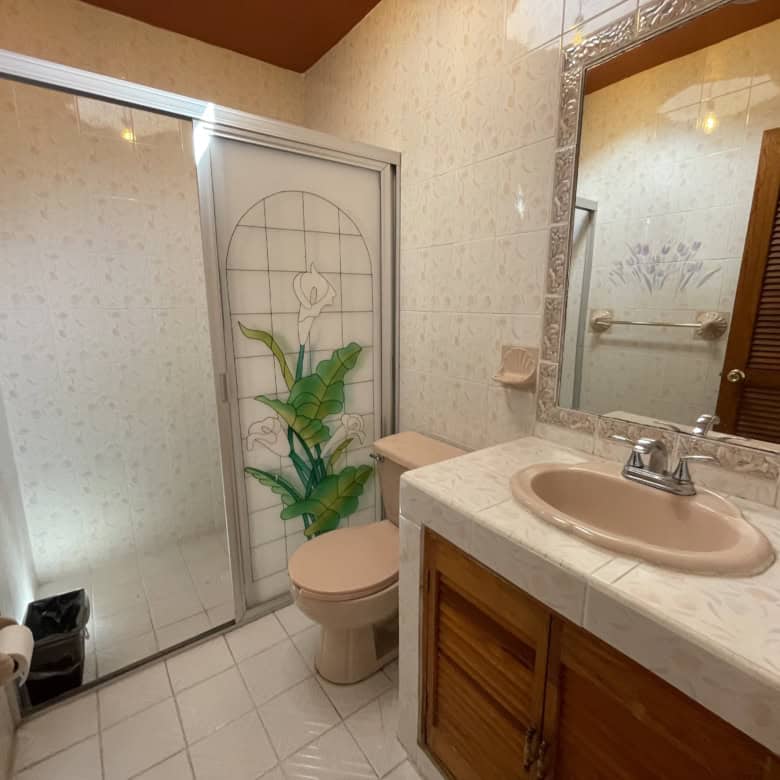 Bright bathroom featuring a shower enclosure and a wooden vanity with a sink.