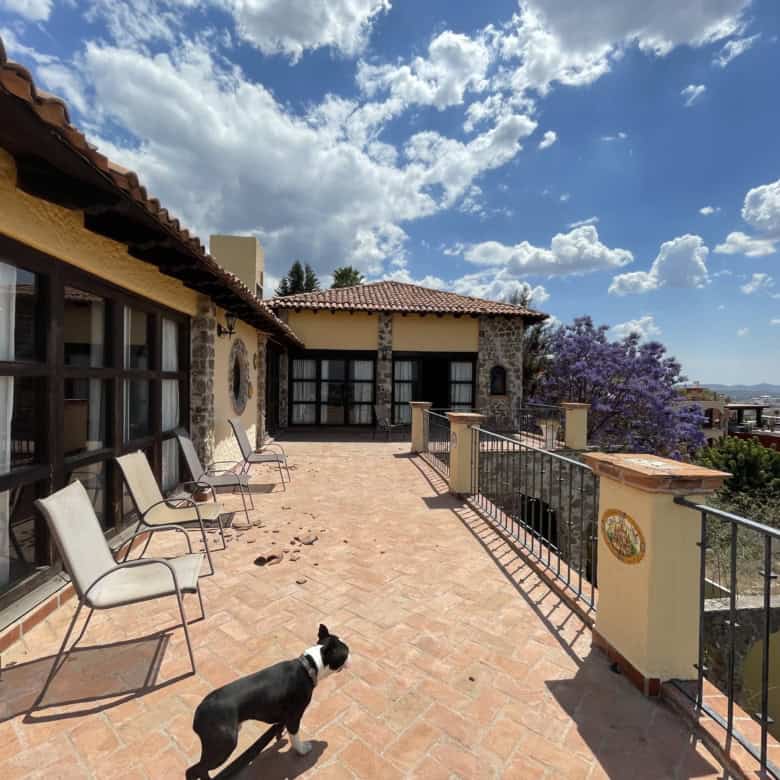 Luxury Spanish villa terrace overlooking cityscape and lush greenery.