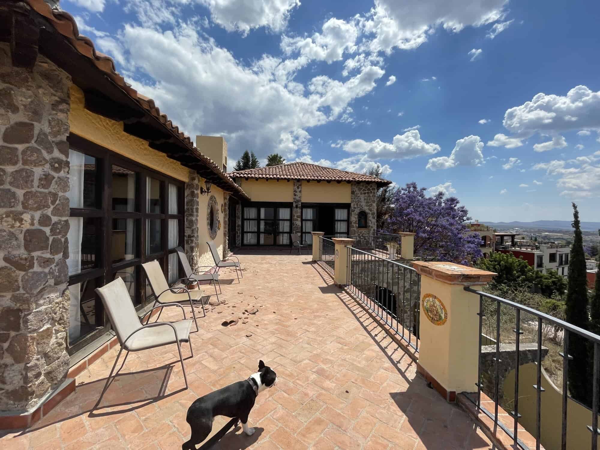 Luxury Spanish villa terrace overlooking cityscape and lush greenery.