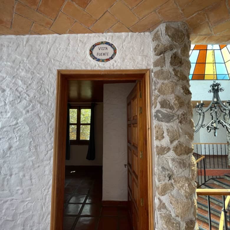 Stone house with view of fountain and interior stairs in international property.