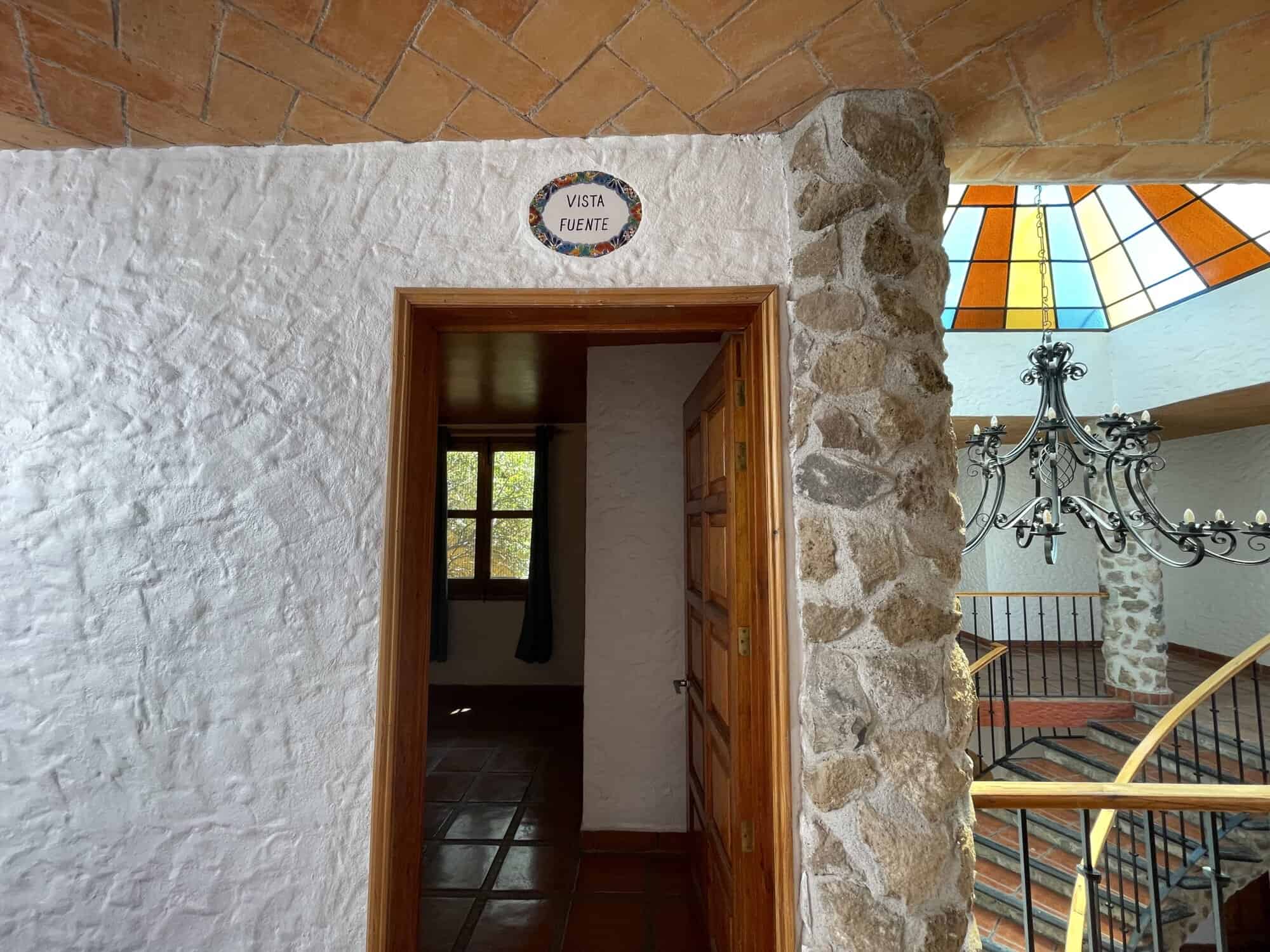 Stone house with view of fountain and interior stairs in international property.