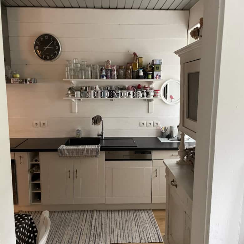 Bright kitchen with white cabinets and open shelving in Altkirch, France.