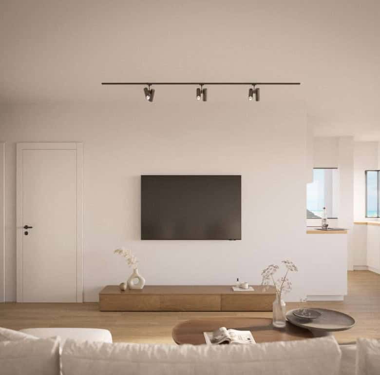 Bright living room with wall-mounted TV and natural light in Sao Bernardino, Portugal.