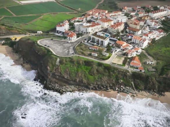 Aerial view of Pôr do Sol in Sao Bernardino, Portugal, showcasing coastal cliffs, colorful houses,.