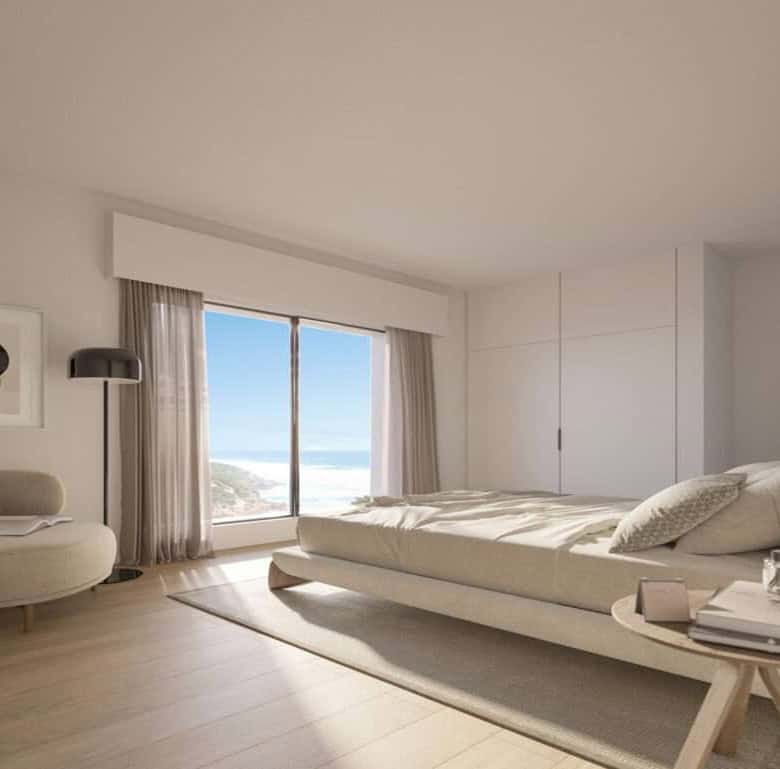 Sea view bedroom with large windows and minimalist decor in São Bernardino, Portugal.