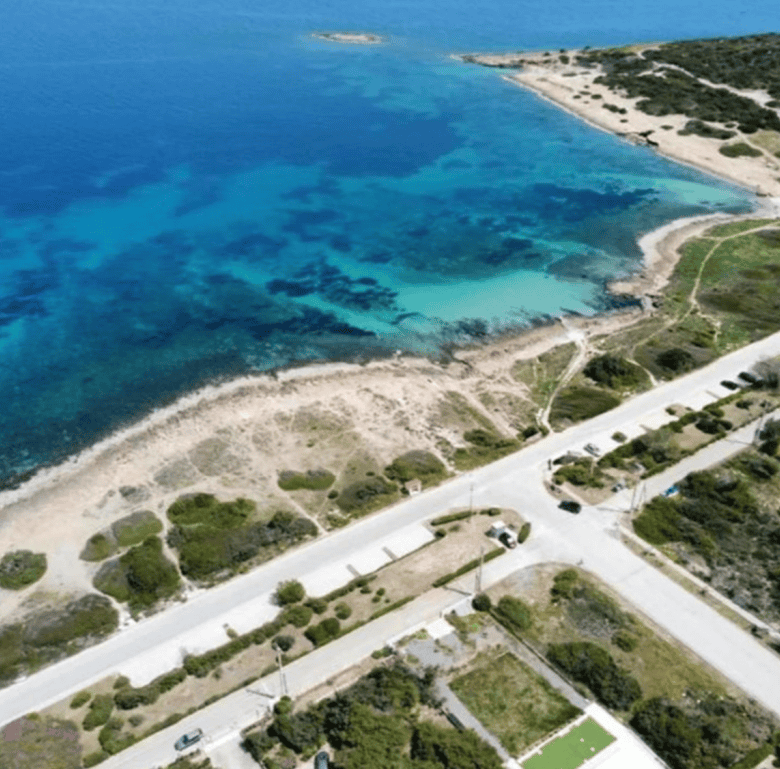 Beach view of Chamilia Beach in Athens, Greece with clear blue waters and sandy shoreline.