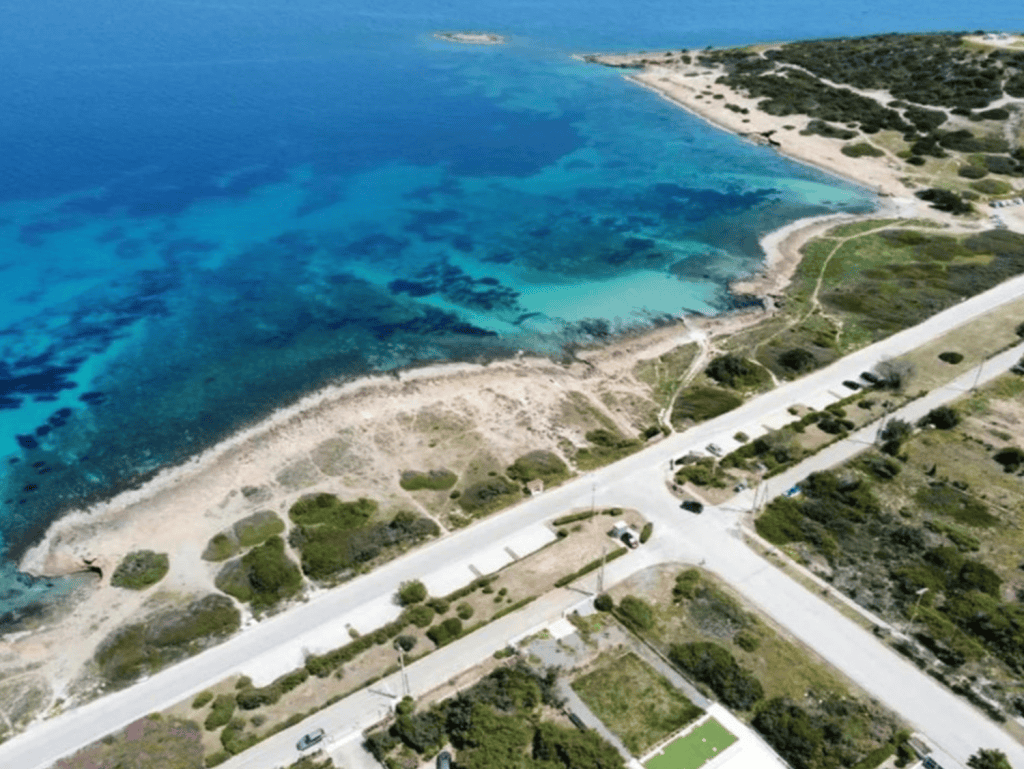 Beach view of Chamilia Beach in Athens, Greece with clear blue waters and sandy shoreline.