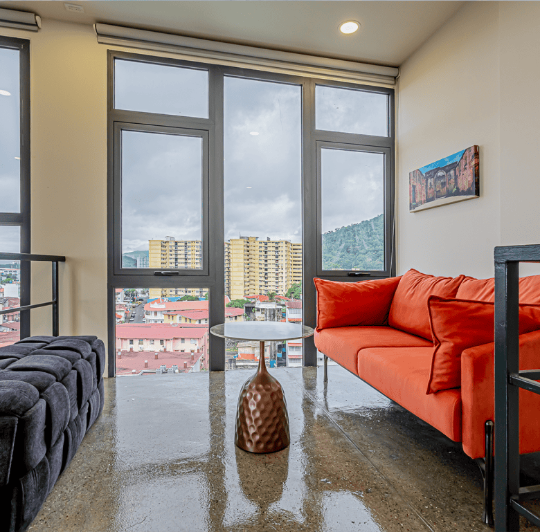 Bright living room with large windows overlooking Panama City skyline.