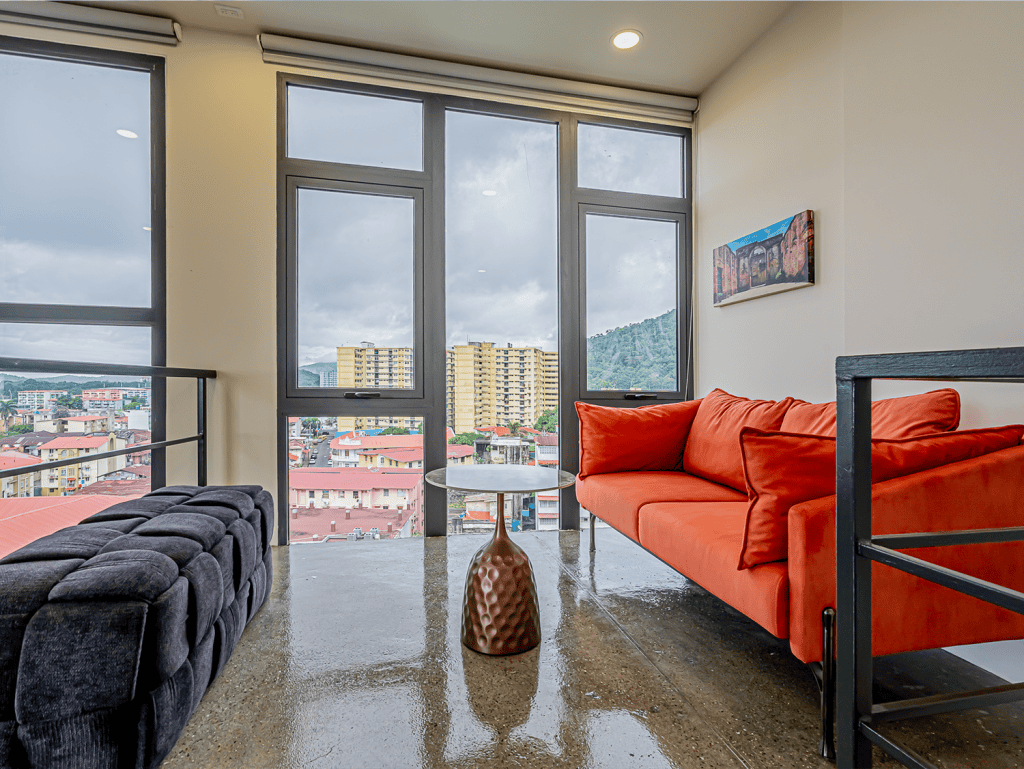 Bright living room with large windows overlooking Panama City skyline.