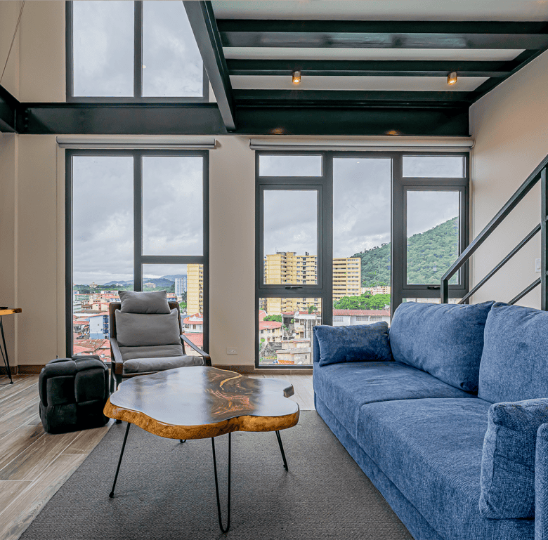 Modern living room with large windows overlooking Panama City skyline.