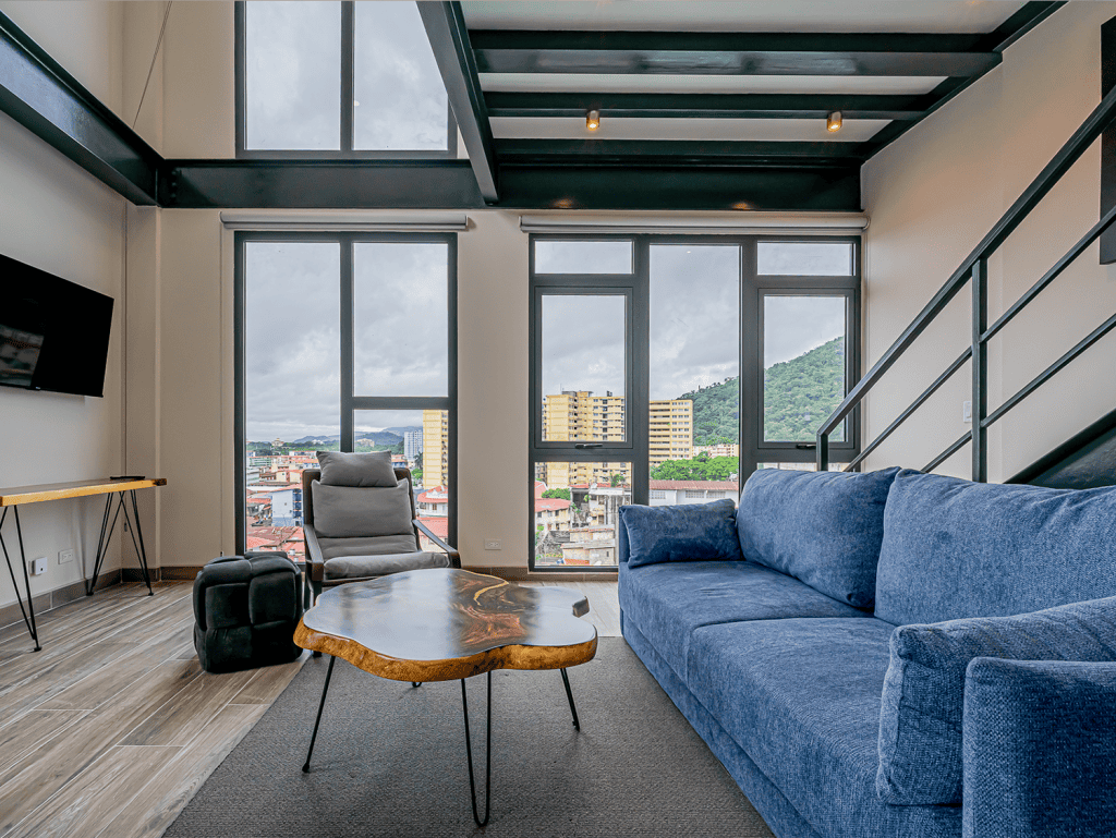 Modern living room with large windows overlooking Panama City skyline.