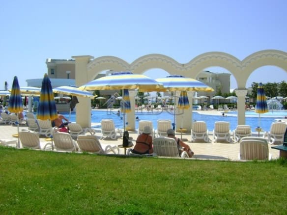 Poolside view at Sunset Resort Pomorie with sun loungers and umbrellas.