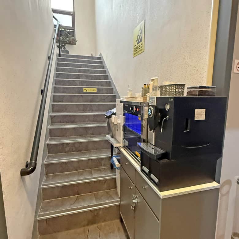 Staircase with handrail and coffee machine in a commercial space.