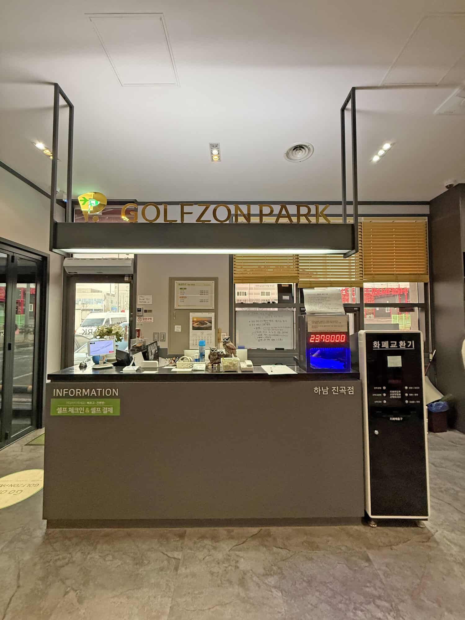 Elegant hotel reception area with check-in counter, currency exchange, and informational displays.