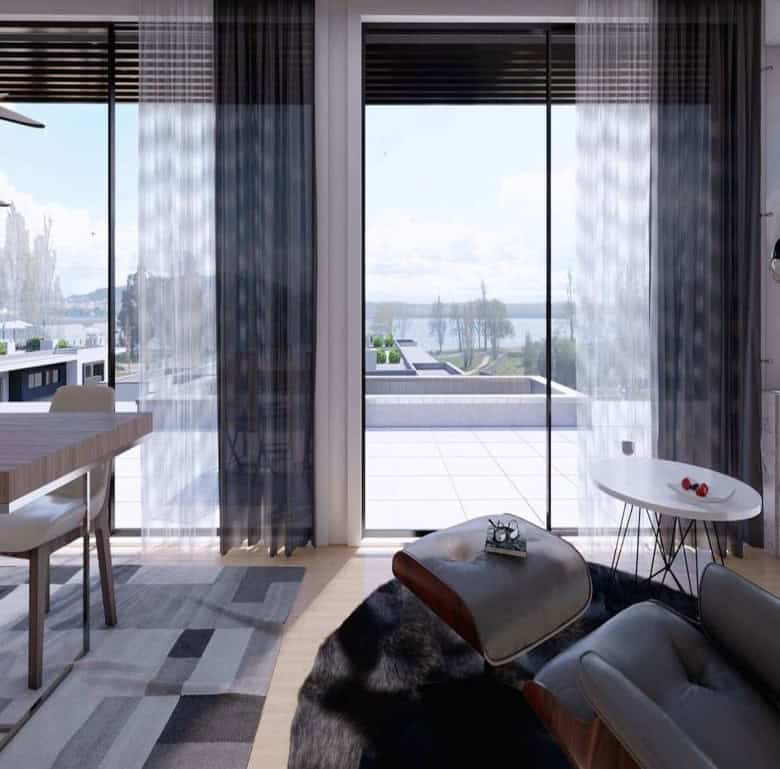 Bright living space with large glass doors opening to scenic river views.