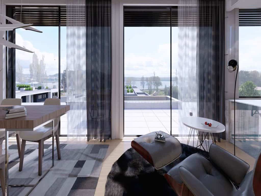 Bright living space with large glass doors opening to scenic river views.