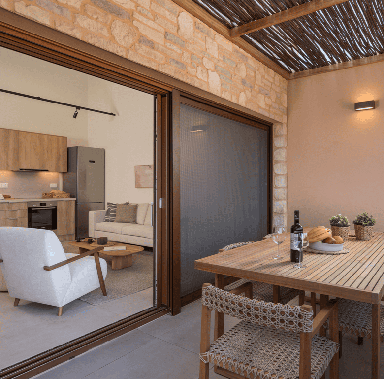 Modern living space with outdoor dining area in Maleme Residences, Crete.