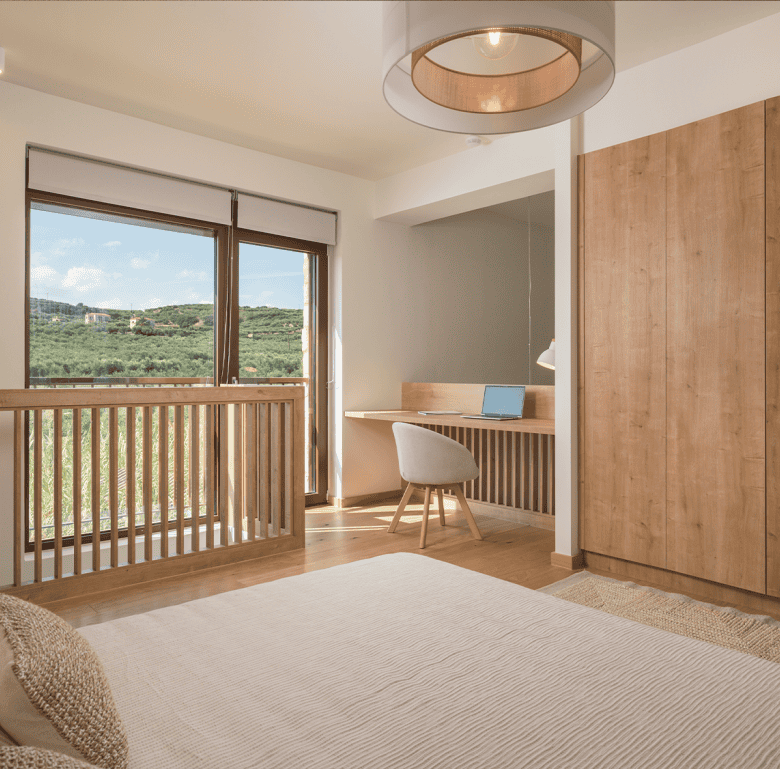 Spacious bedroom in Maleme Residences, Crete, Greece, featuring natural light and scenic views.
