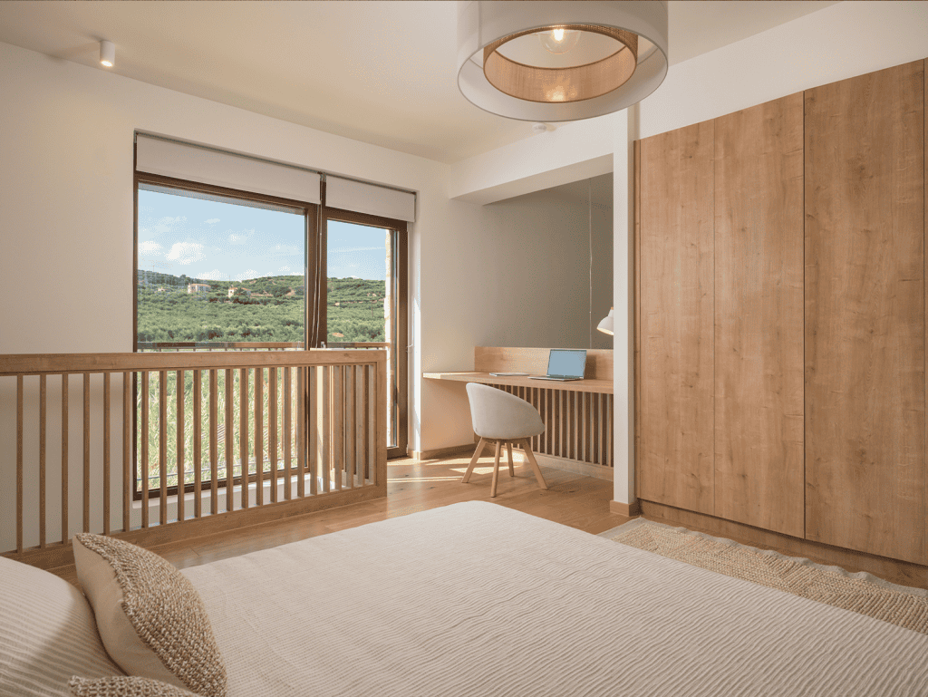 Spacious bedroom in Maleme Residences, Crete, Greece, featuring natural light and scenic views.