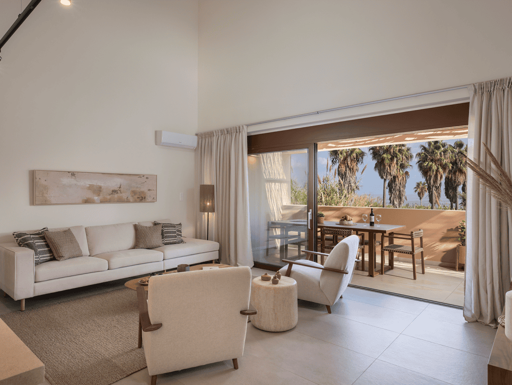 Spacious living room with modern furniture and large glass doors opening to a balcony.