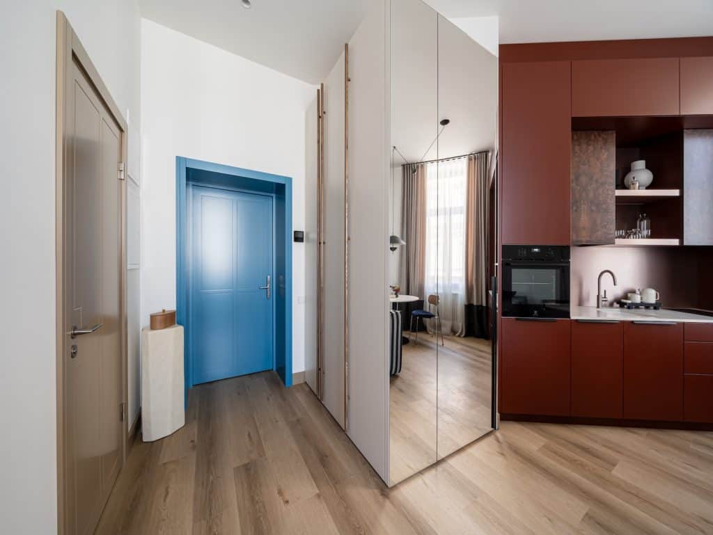 Bright Riga property with contemporary design, featuring a vibrant blue door and open-plan living sp.