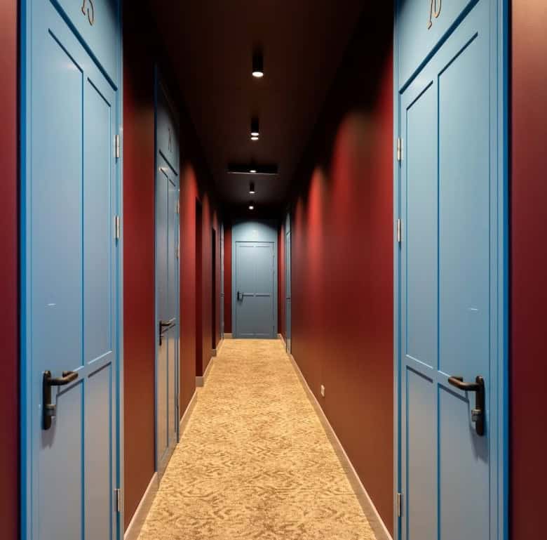 Hotel corridor with blue doors and warm lighting in Riga, Latvia.