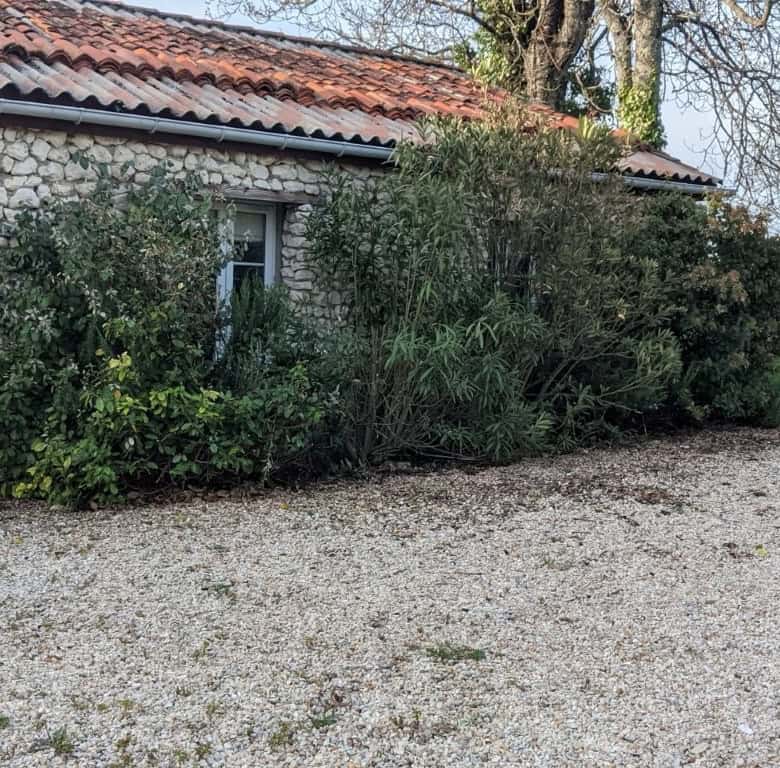 Equestrian property with lush gardens and rustic stone exterior in Chatignac, France.
