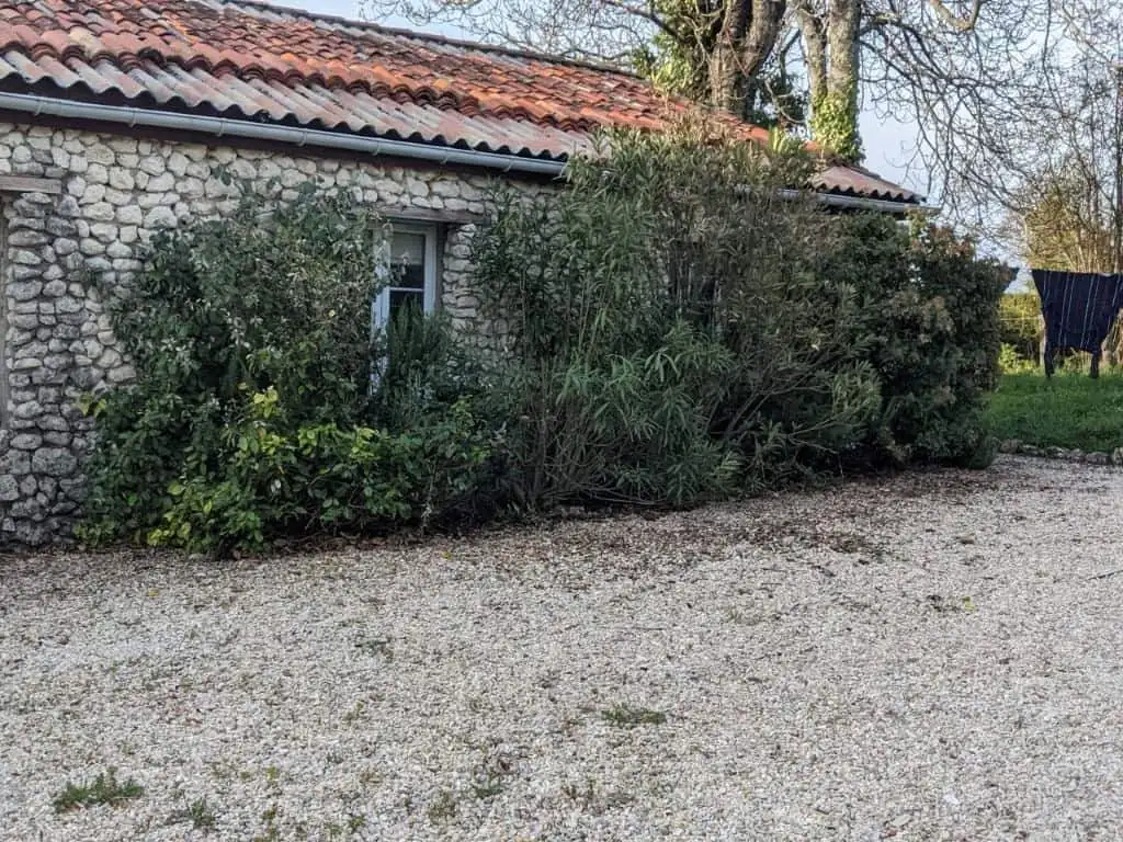 Equestrian property with lush gardens and rustic stone exterior in Chatignac, France.