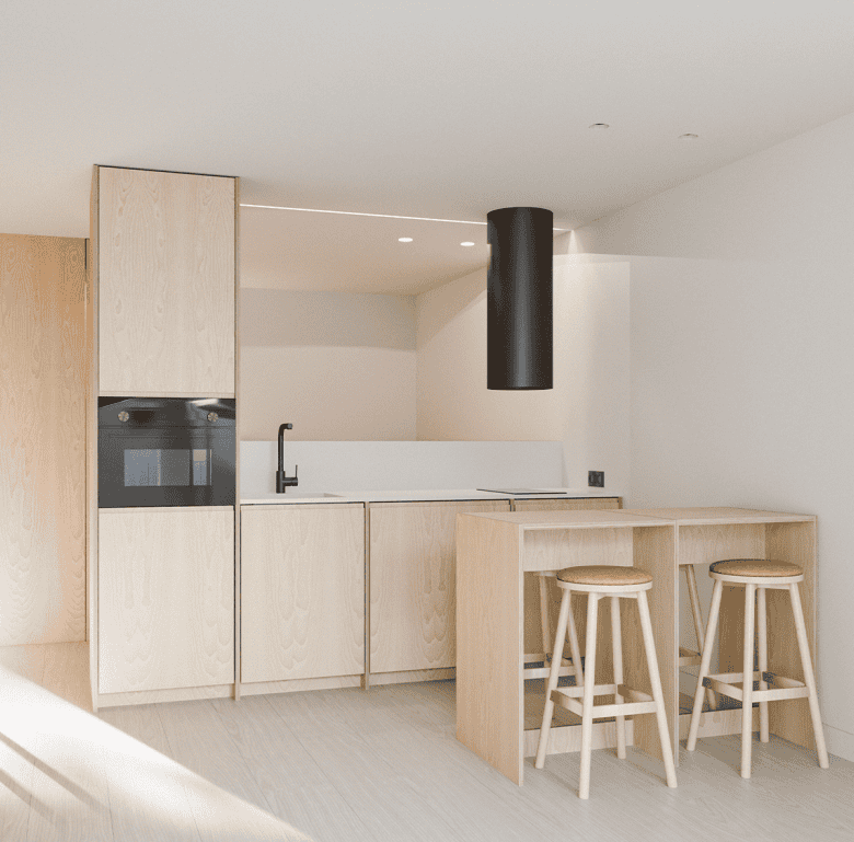 Modern kitchen with light wood cabinets and minimalist design in Pilar Apartments, Porto, Portugal.