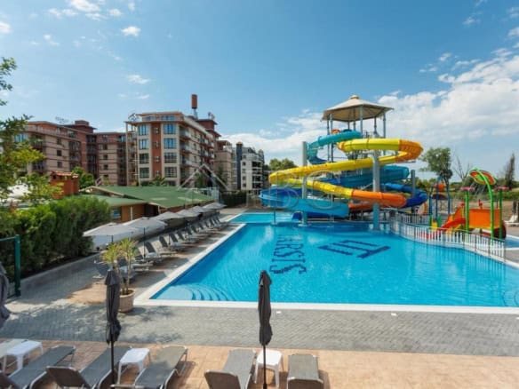 Bright outdoor swimming pool with colorful water slides at Tarsis Nova, Sunny Beach. Perfect for rel.