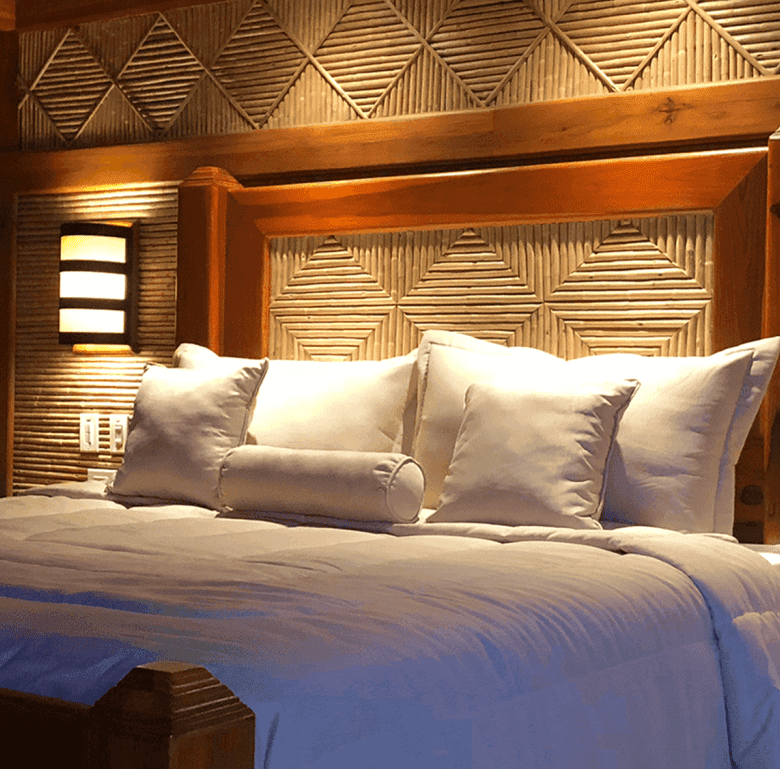Comfortable bedroom with wooden decor and plush bedding in Arenal Hills, La Fortuna, Costa Rica.