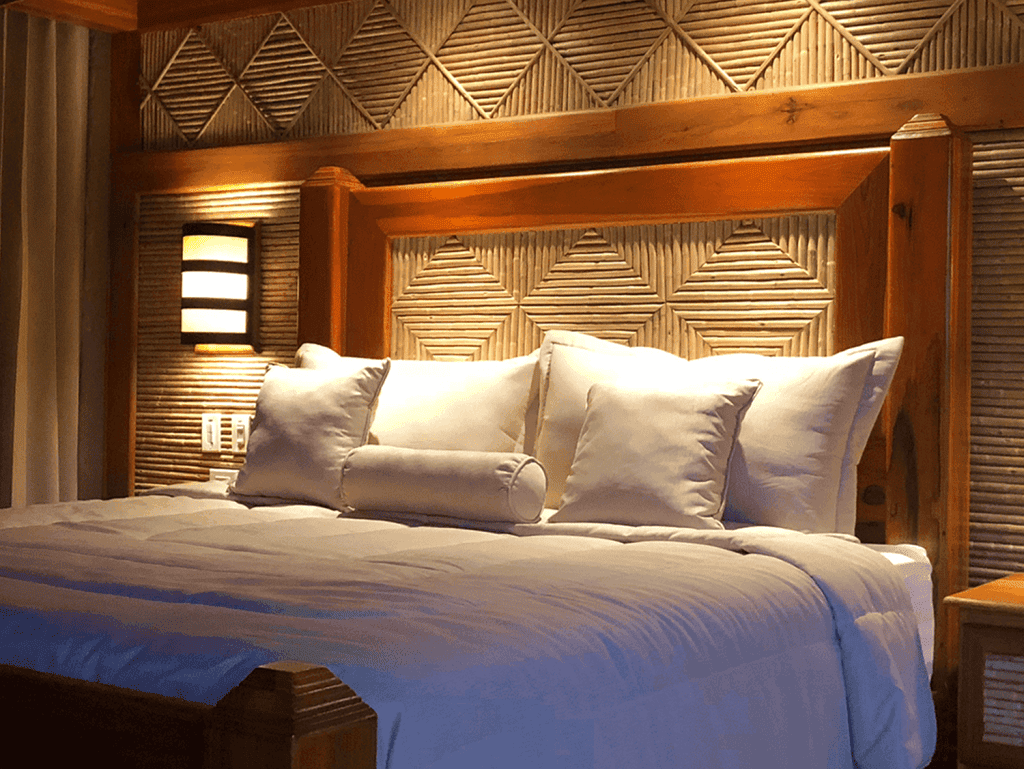 Comfortable bedroom with wooden decor and plush bedding in Arenal Hills, La Fortuna, Costa Rica.