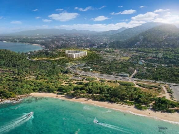 Beachfront view of Surin Beach with turquoise waters and lush greenery in Phuket, Thailand.