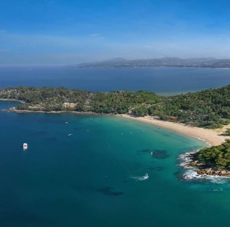 Beautiful aerial view of Surin Beach in Phuket, Thailand with clear blue waters and lush green surro.