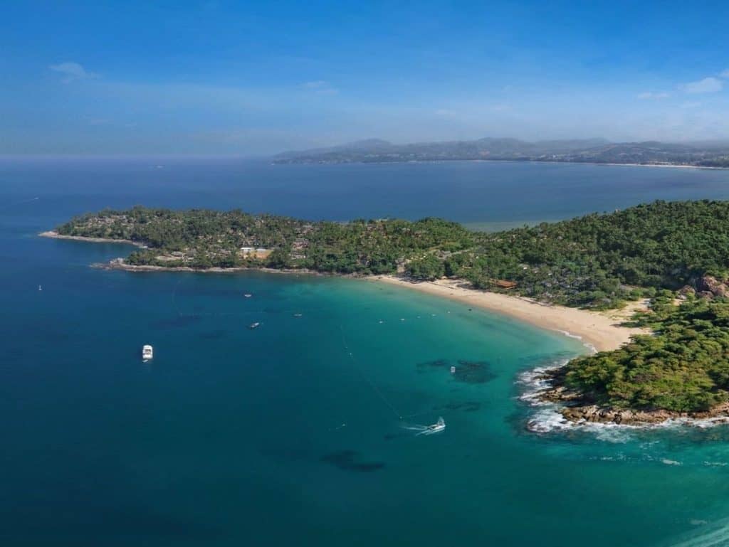 Beautiful aerial view of Surin Beach in Phuket, Thailand with clear blue waters and lush green surro.