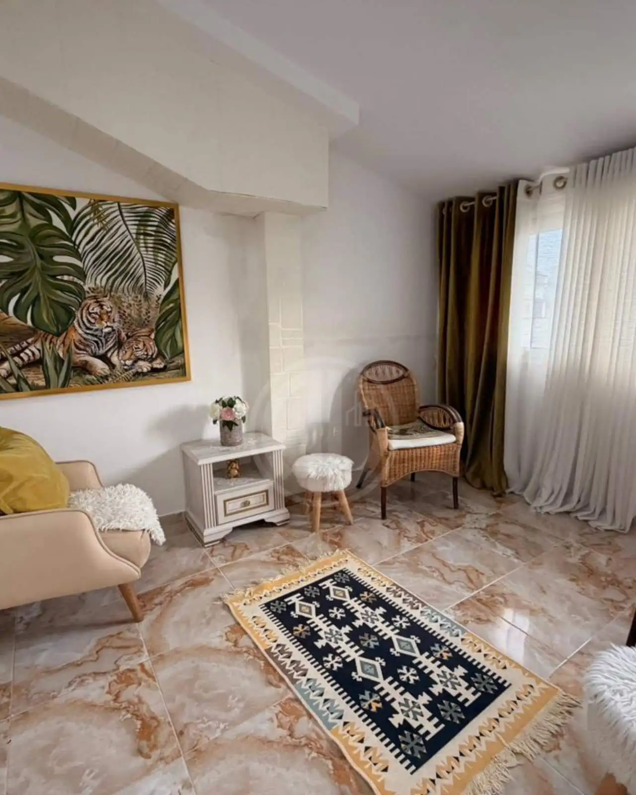 Contemporary living room featuring elegant furniture, a vibrant painting, and cozy accents.