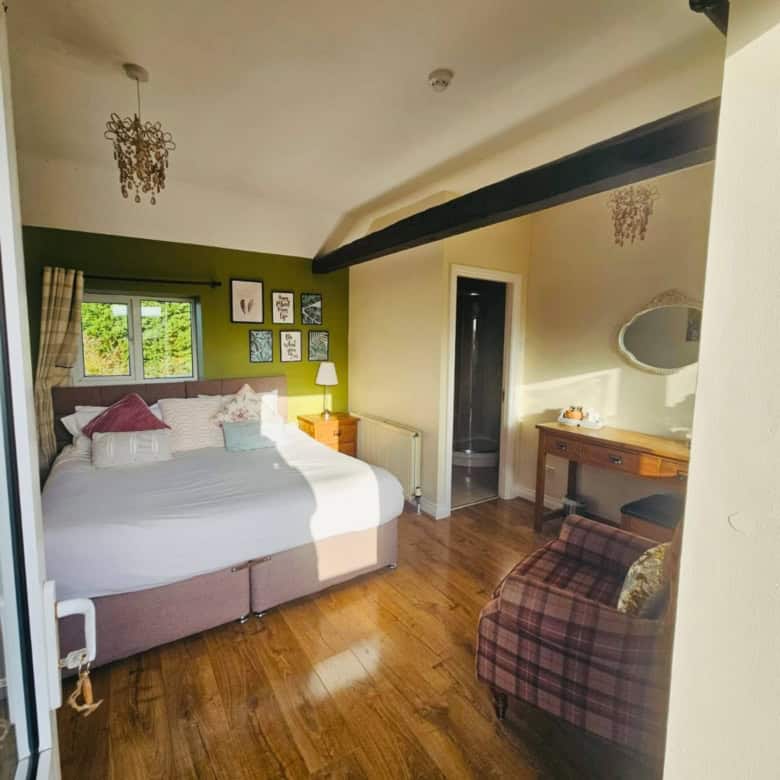 Charming bedroom with vintage decor, wooden flooring, and natural light from the window.