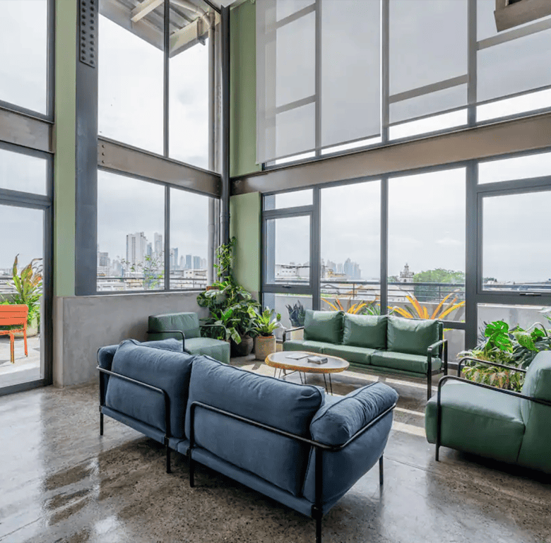 Spacious interior featuring large windows and stylish furniture overlooking the skyline.