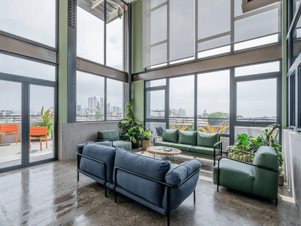 Spacious interior featuring large windows and stylish furniture overlooking the skyline.