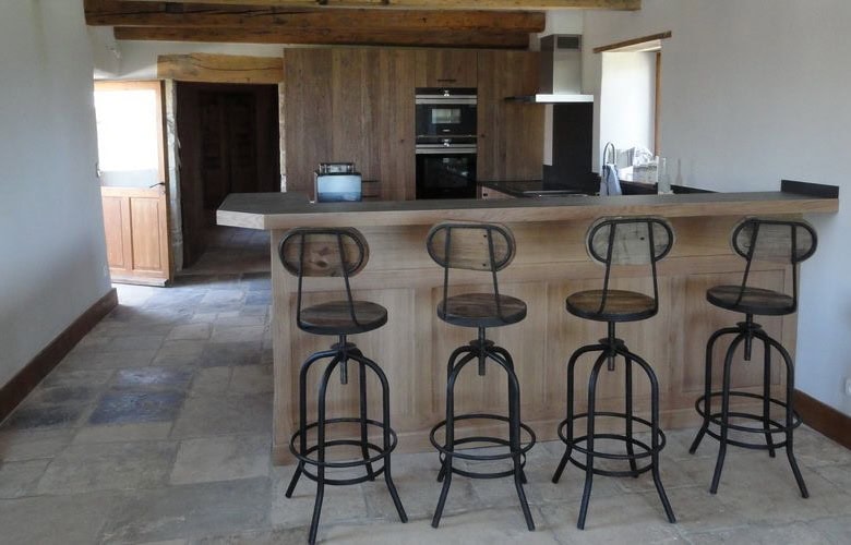 Elegant kitchen featuring a breakfast bar with four stylish stools in a luxurious French estate.