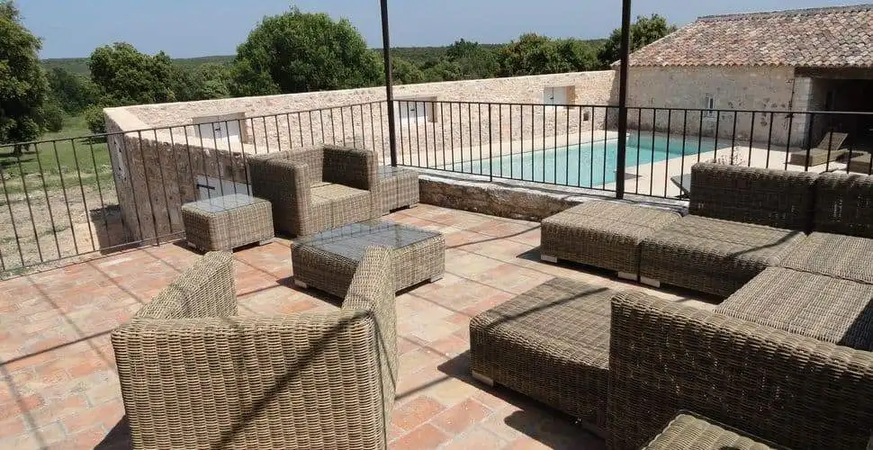Elegant outdoor seating area with pool at Domaine de La Quiquier estate in Goudargues, France.