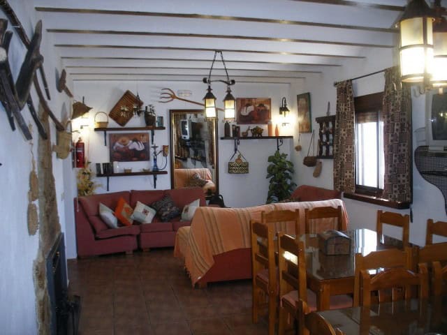 Interior view of a traditional cave house in Cuevas del Campo, Granada, showcasing rustic decor and.