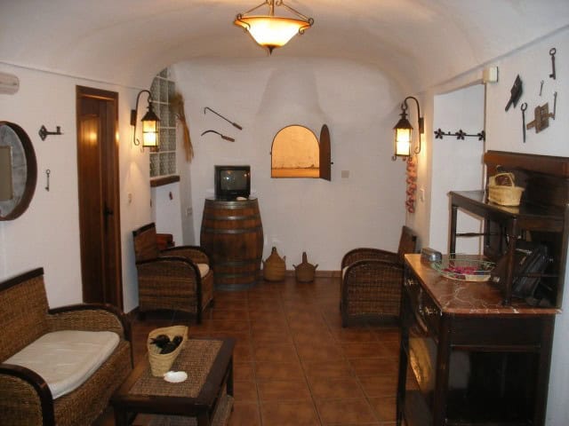 Charming cave house living room with rustic furniture and traditional decor in Cuevas del Campo, Gra.