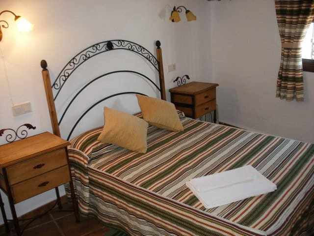 Cave house bedroom with rustic decor, twin beds, and traditional furnishings in Cuevas del Campo, Gr.