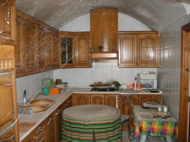 Unique cave house kitchen in Gorafe, Granada with wooden cabinets and rustic interior.