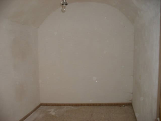 Interior of a cave house in Gorafe, Granada, showing smooth, whitewashed walls and a simple ceiling.