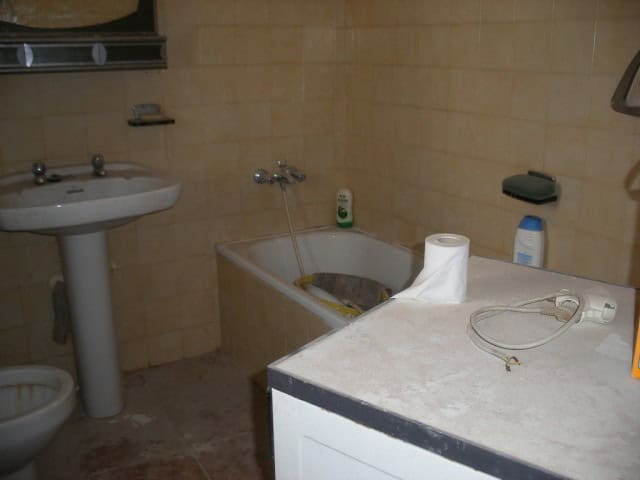 Cave house bathroom with bathtub, sink, and basic amenities in Gorafe, Granada.